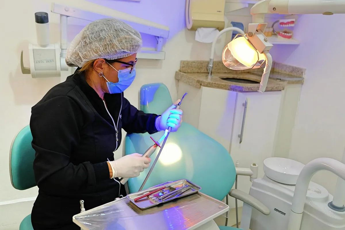 Dentysta w klinice używający narzędzi dentystycznych i sprzętu do opieki nad pacjentem