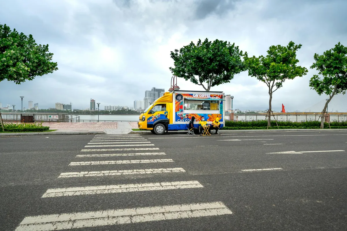 Food truck — A vibrant food truck parked on an empty city street with a s