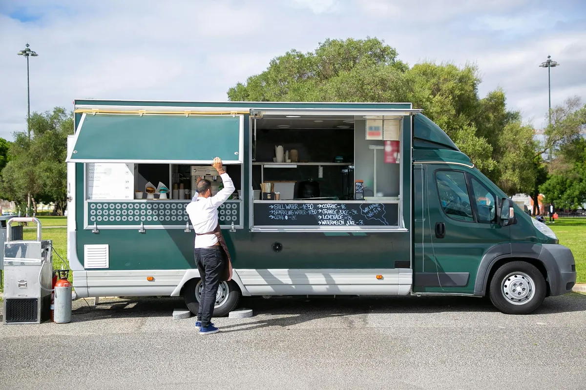Food truck — Back view full body of anonymous male worker opening windows