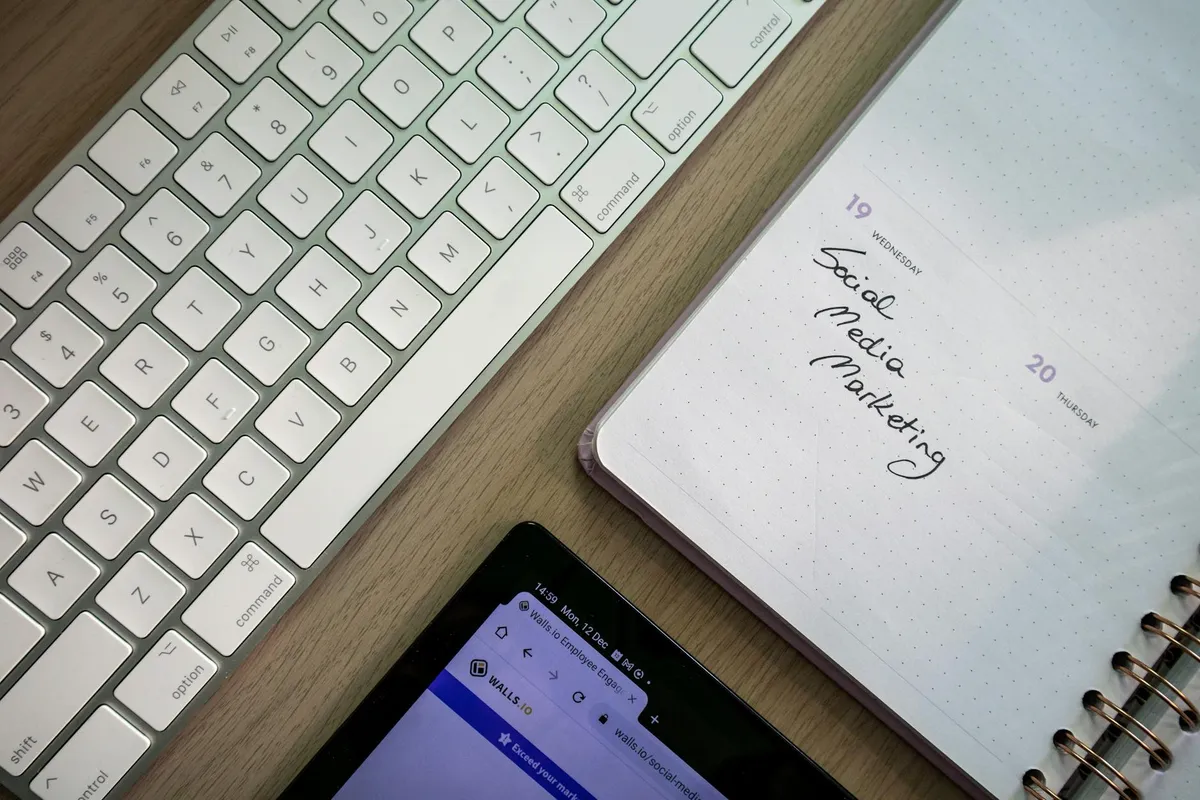 Widok z góry klawiatury, planera z notatką o marketingu mediów społecznych i tabletu na biurku