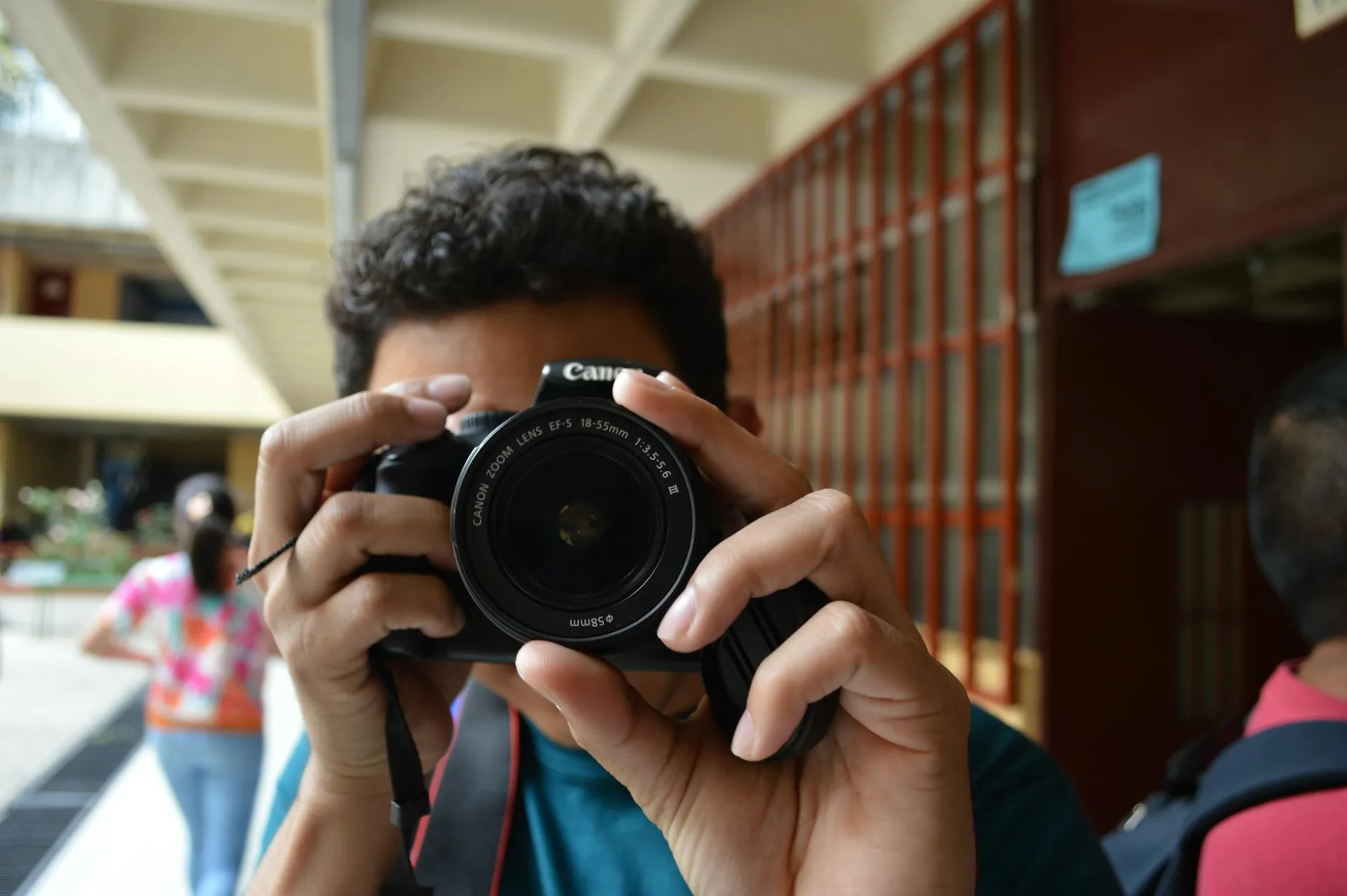 Zbliżenie osoby robiącej zdjęcie wewnątrz za pomocą aparatu DSLR