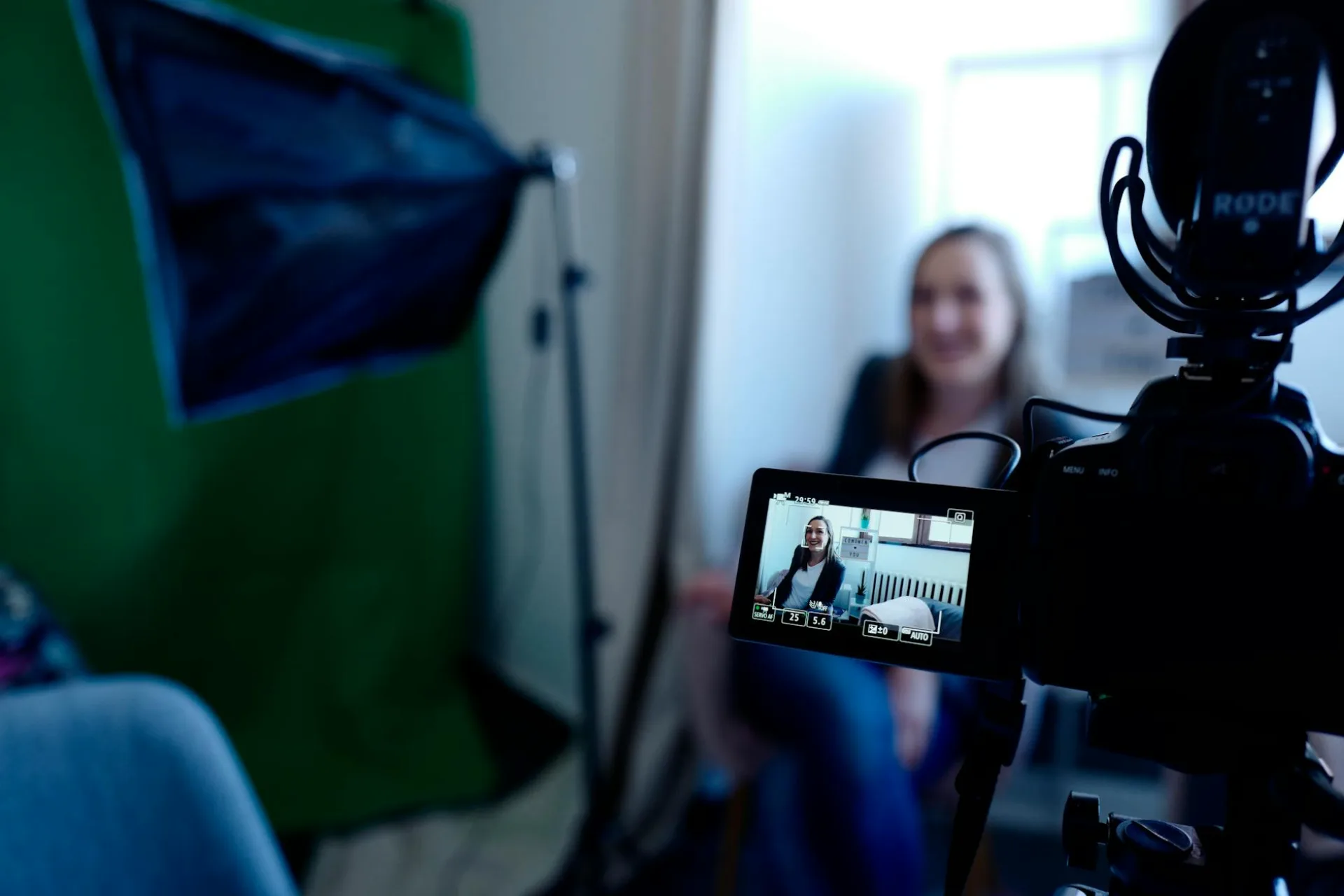 Kobieta nagrywana w profesjonalnym studiu, używająca kamery wideo i sprzętu oświetleniowego