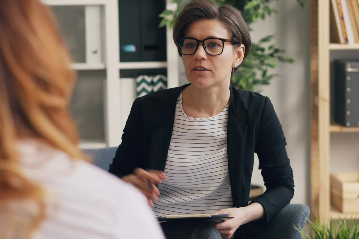 Profesjonalny terapeuta w nowoczesnym biurze zaangażowany w dyskusję z klientem