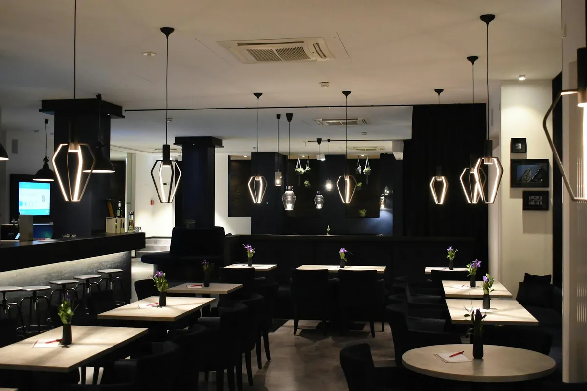 Eleganckie wnętrze restauracji ze stołami z drewna i ciepłym oświetleniem